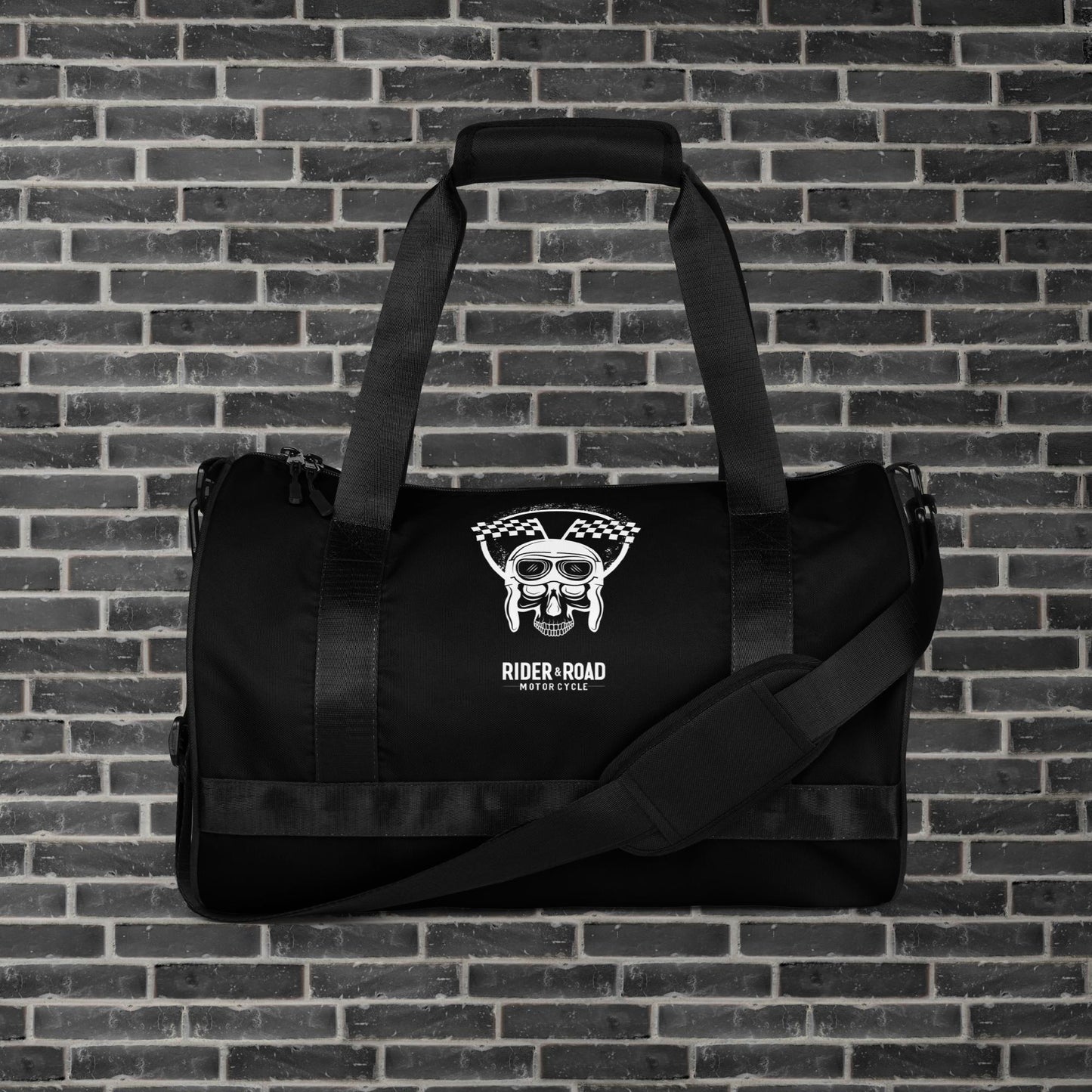 "Bolsa cilíndrica de 30 litros, color negro, con imagen estampada de una calavera con gorro de piloto de cuero y gafas, sobre la frase Rider&Road Motorcycle - 30-liter cylindrical bag, black, with a printed image of a skull wearing a leather pilot's cap and goggles, above the phrase Rider&Road Motorcycle"