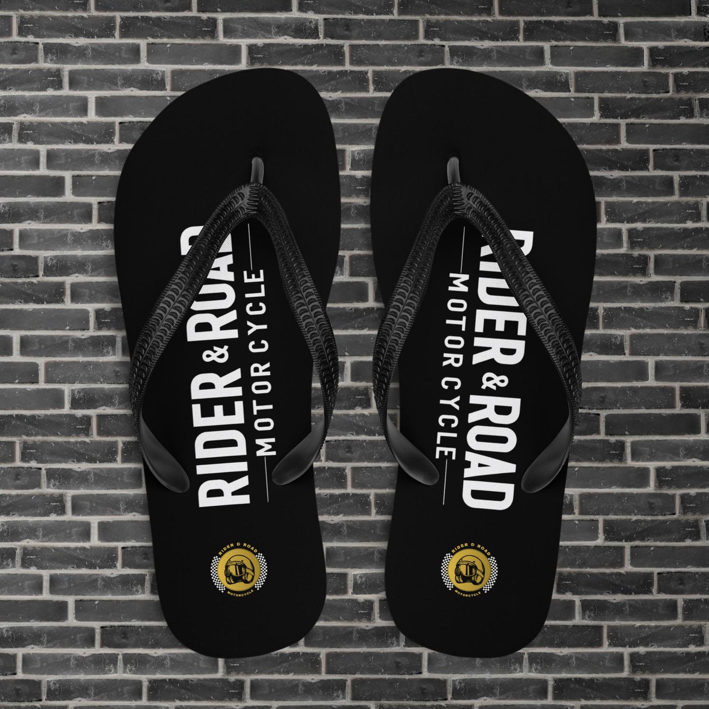 "Chanclas flip flop de goma negra, con el logo de Rider&Road Motorcycle en la zona del pie - Black rubber flip flops with the Rider&Road Motorcycle logo on the foot area"