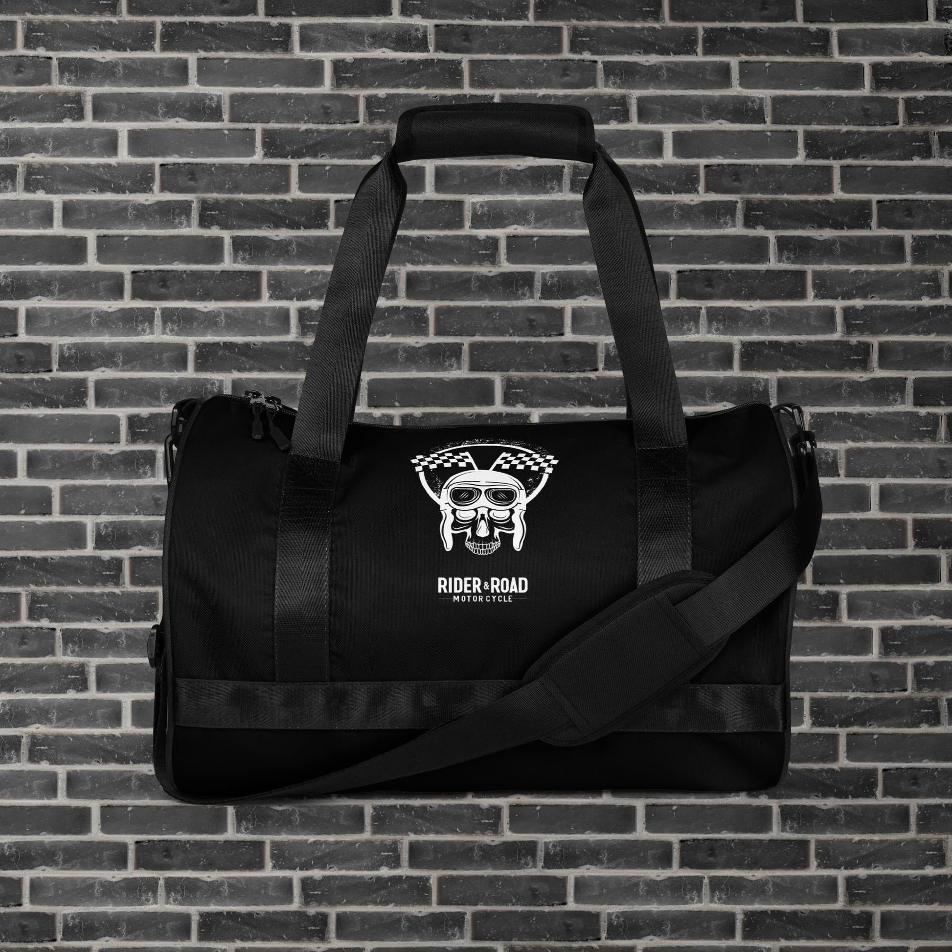 "Bolsa cilíndrica de 30 litros, color negro, con imagen estampada de una calavera con gorro de piloto de cuero y gafas, sobre la frase Rider&Road Motorcycle - 30-liter cylindrical bag, black, with a printed image of a skull wearing a leather pilot's cap and goggles, above the phrase Rider&Road Motorcycle"