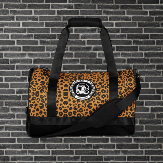 "Bolsa cilíndrica estilo motero con estampado de leopardo, ideal para entrenamientos y escapadas urbanas con logo clásico de Rider&Road - ‘Cylindrical biker-style bag with leopard print, ideal for training sessions and urban getaways, featuring the classic Rider&Road logo"