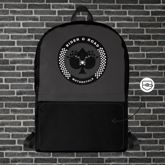 "Mochila color negro y gris oscuro con el el As de Picas y un manillar en su interior dentro de un circulo con el nombre "Rider & Road Motorcycle" - Black and dark grey backpack with the Ace of Spades and a handlebar inside a circle with the name ‘Rider & Road Motorcycle"