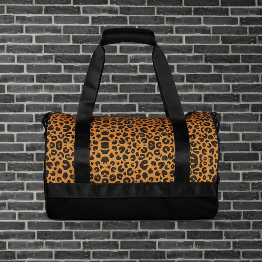 "Bolsa cilíndrica estilo motero con estampado de leopardo, ideal para entrenamientos y escapadas urbanas con logo clásico de Rider&Road - ‘Cylindrical biker-style bag with leopard print, ideal for training sessions and urban getaways, featuring the classic Rider&Road logo"