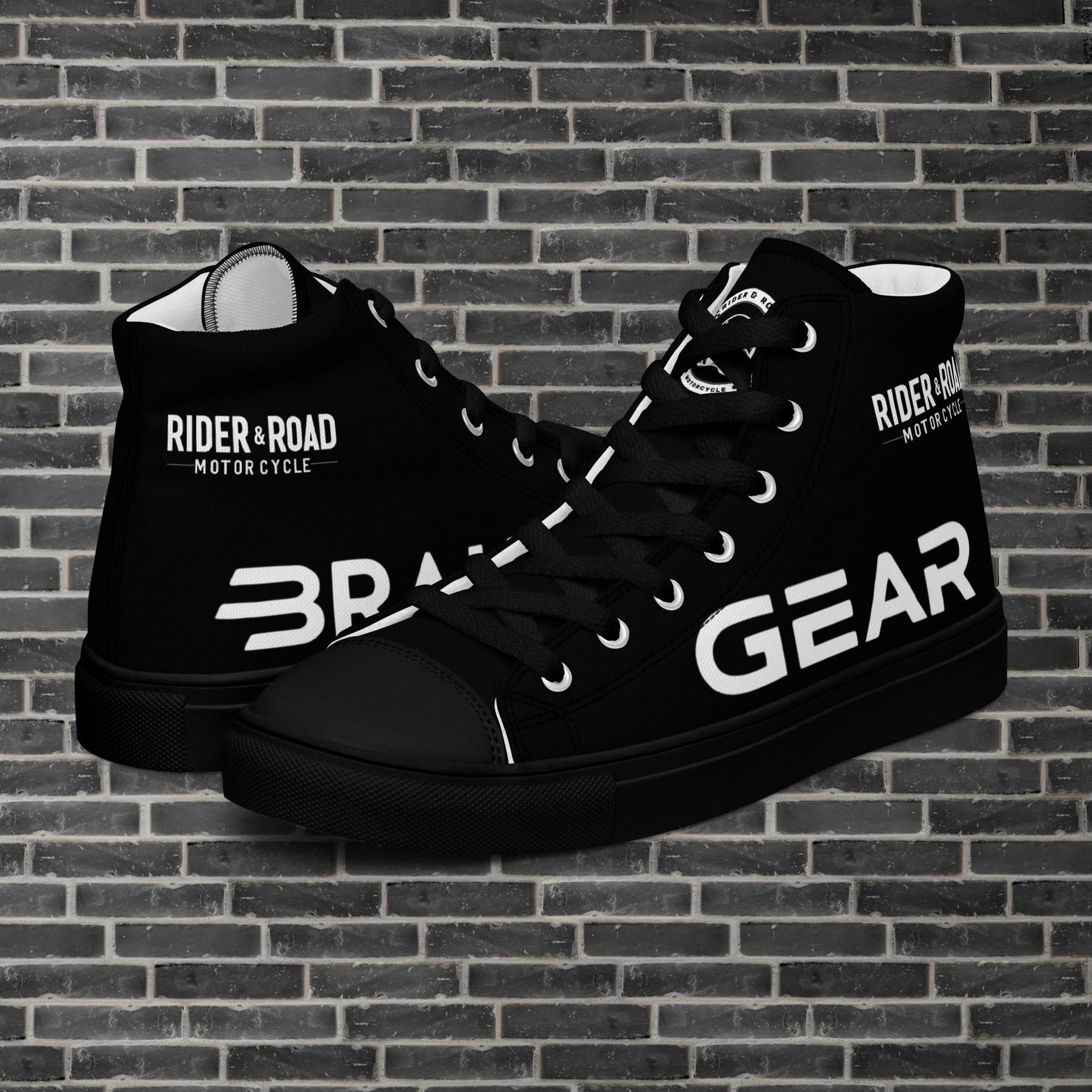 "Zapatilla negra con puntera y suela de goma, tiene estampado en el pie derecho la palabra brake y en el izquierdo gear, haciendo referencia la posición del freno y los cambios en las motos - Black trainers with rubber toes and soles, with the word “brake” printed on the right foot and “gear” on the left, referring to the position of the brake and gears on motorcycles"