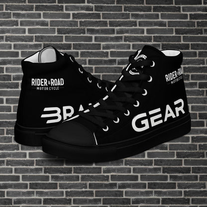 "Zapatilla negra con puntera y suela de goma, tiene estampado en el pie derecho la palabra brake y en el izquierdo gear, haciendo referencia la posición del freno y los cambios en las motos - Black trainers with rubber toes and soles, with the word “brake” printed on the right foot and “gear” on the left, referring to the position of the brake and gears on motorcycles"