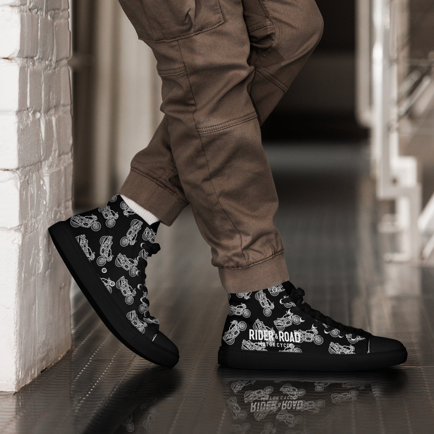 "Zapatillas altas en cuero sintético negro, suela gruesa y diseño minimalista con espíritu motero, motos clasicas blancas sobre fondo negro colección Rider & Road - ‘High-top trainers in black synthetic leather, thick sole and minimalist design with a biker spirit, classic white motorcycles on a black background — Rider & Road collection"