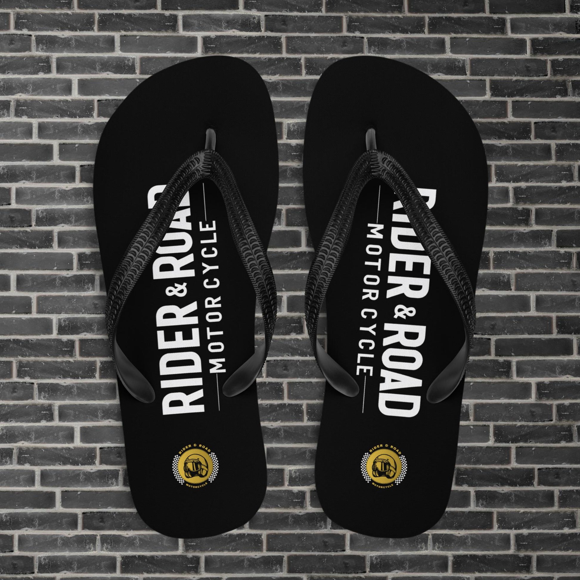 "Chanclas flip flop de goma negra, con el logo de Rider&Road Motorcycle en la zona del pie - Black rubber flip flops with the Rider&Road Motorcycle logo on the foot area"
