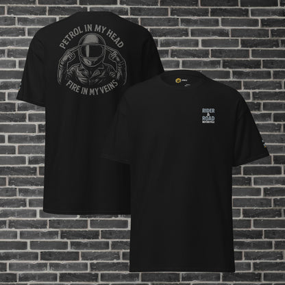 "Camiseta negra con estampado en la parte trasera en color gris de un motero con los dedos apuntando a la cabeza y la frase petrol in my head, fire in my veins, tiene bordado el logo de Rider&Road en el pecho y en la manga izquierda - Black T-shirt with a gray print on the back of a biker with his fingers pointing to his head and the phrase ‘petrol in my head, fire in my veins’. It has the Rider&Road logo embroidered on the chest and left sleeve"
